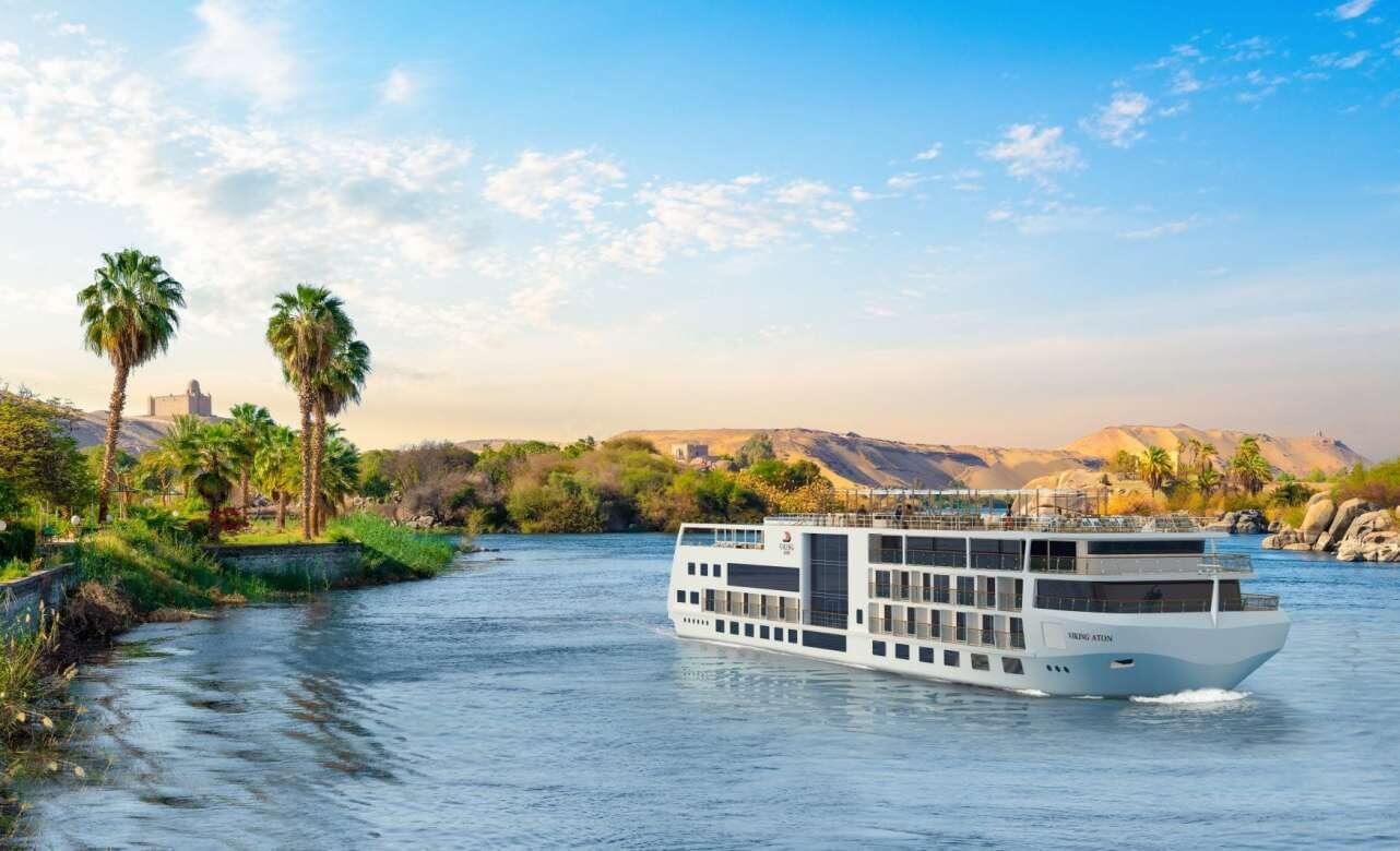 Crucero navegando el río Nilo en Egipto, rodeado de palmeras y dunas