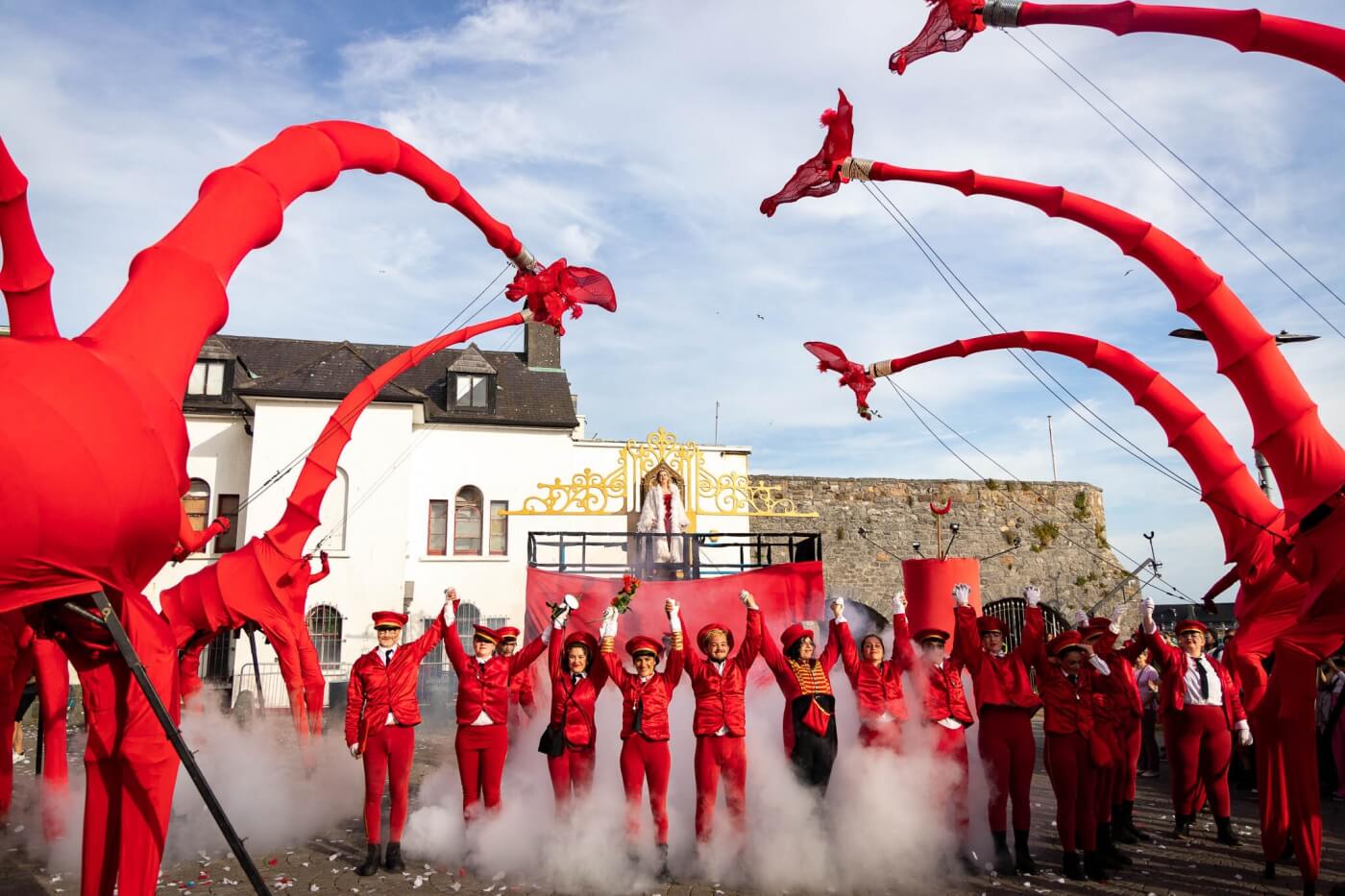 Espectáculo callejero con artistas vestidos de rojo en el festival de Galway en verano