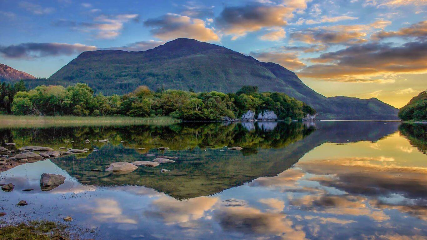 Lago reflejando montañas al atardecer en el Parque Nacional de Killarney.