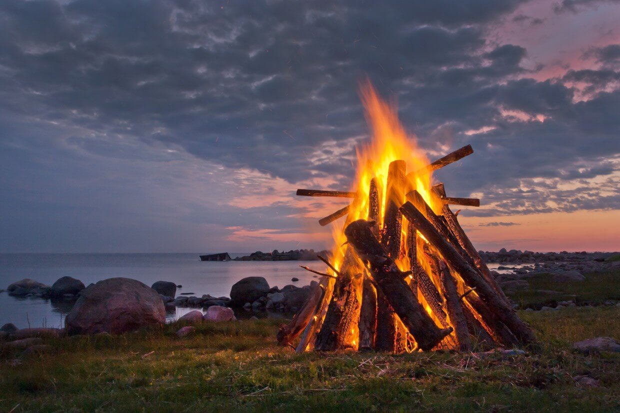 Hoguera tradicional en la costa durante la celebración del solsticio de verano en Laponia.